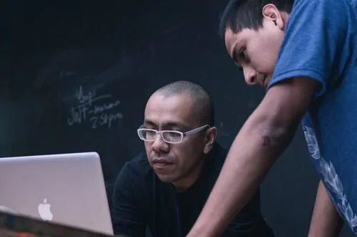 Teacher and student looking at a laptop screen